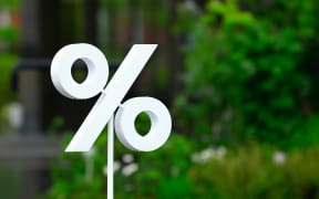 A percentage sign, in front of an urban scene.