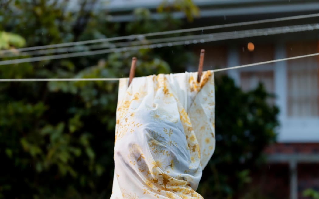 Mary (Maya Le Roux) is wrapped in a sheet at the clothesline.