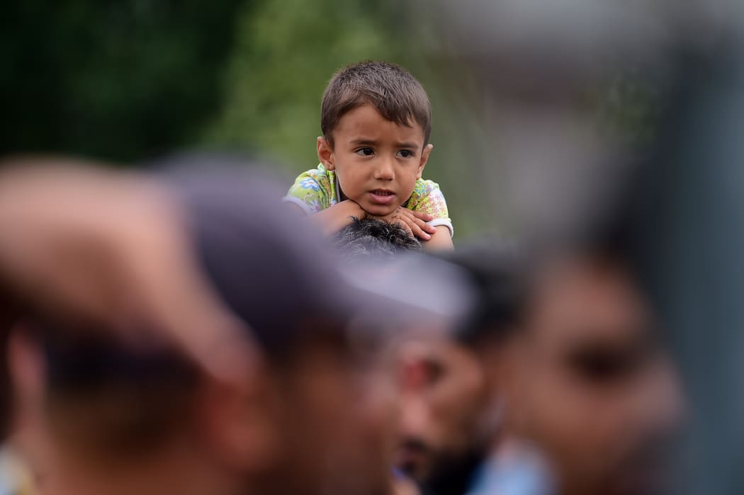 A young migrant boy sits on his father's shoulders at the Hungarian-Austrian border in Heiligenkreuz, Austria.