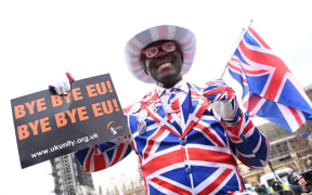 (FILES) In this file photo taken on January 31, 2020 Joseph Afrane, bedecked in Union flag colours, holds up a sign saying "Bye bye EU" on Parliament Square opposite the Houses of Parliament in London on January 31, 2020 on the day that the UK formally leaves the European Union.