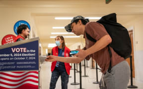 A voter drops off a ballot at an official ballot drop box at the San Francisco City Hall voting centre on the final day of early voting ahead of Election Day, on 4 November, 2024 in San Francisco, California.