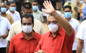 Sri Lankan president Gotabaya Rajapaksa wearing a face mask gestures as he leaves after casting his vote for the parliamentary election at a polling station in Colombo.