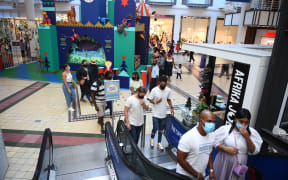 People wearing masks walk at a shopping mall as they continue their daily life amid Covid-19 in Cape Town, South Africa on December 27, 2020.