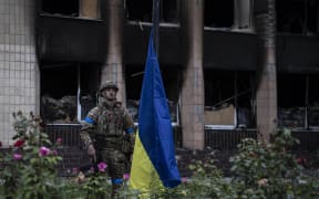 IZIUM, KHARKIV, UKRAINE - SEPTEMBER 14: Ukrainian soldiers stand guard as Ukrainian President Volodymyr Zelenskyy attends flag hoisting ceremony in Izium after the Ukrainian forces took control of the city from the Russian forces in Kharkiv, Ukraine on September 14, 2022. Metin AktaÅŸ / Anadolu Agency (Photo by Metin AktaÅŸ / ANADOLU AGENCY / Anadolu Agency via AFP)