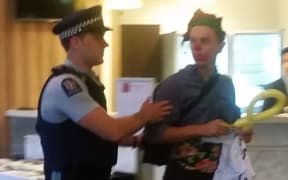 Police remove protestors from a TPP roadshow workshop in Auckland.