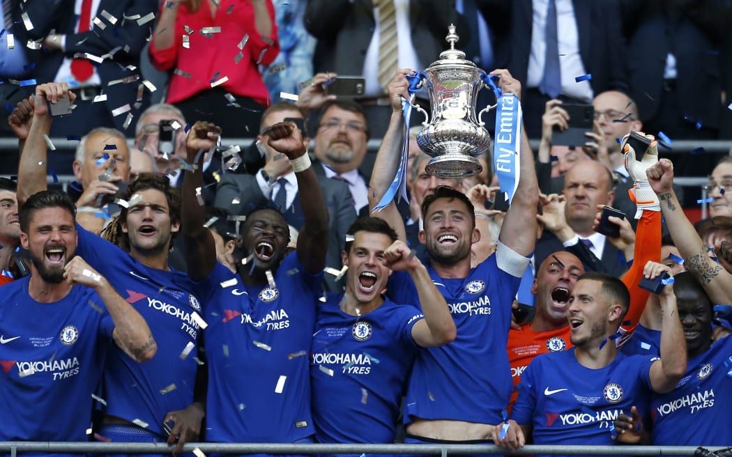 Chelsea's English defender Gary Cahill lifts the trophy as Chelsea players celebrate their win after the English FA Cup final football match between Chelsea and Manchester United.