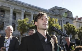 Refugee Quote Protest. Protest organiser Murdoch Stephens speaks to the crowd outside Parliament.