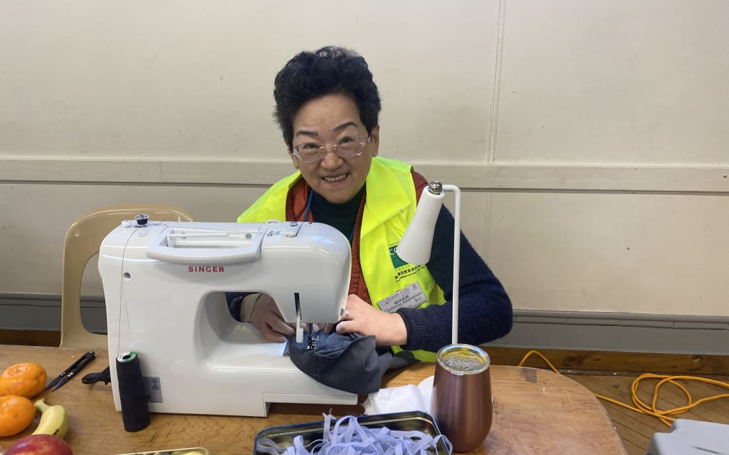 Chinese volunteers help people sew their clothes at the Repair Cafe in Auckland.