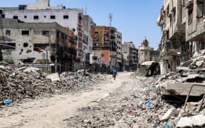 A man walks past rubble and damaged buildings along a street in the Tuffah district east of Gaza City on 8 July, 2024 amid the ongoing conflict in the Palestinian territory between Israel and Hamas.