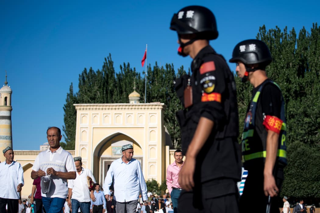 Police patrolling as Muslims leave the Id Kah Mosque after the morning prayer on Eid al-Fitr in the town of Kashgar in China's Xinjiang region on June 26, 2017.