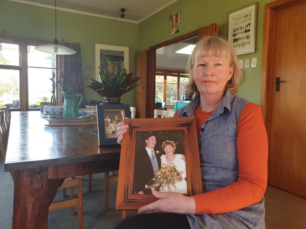 Heather Gregory, with a wedding photo showing her late husband Richard.