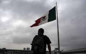 A Mexican deported from the US is seen next to a Mexican national flag at El Chaparral repatriation center in Tijuana, northwestern Mexico, in the border with the US.