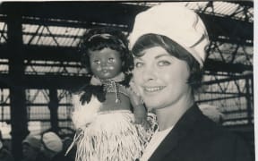 Joan Harnett on tour for the Silver Ferns, holding the team's mascot.