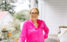 Linda Tuhiwai Smith wears a pink shirt and smiles at the camera.
