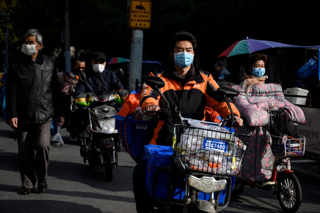 Motorists wearing face masks, amid concerns over the spread of the COVID-19 novel coronavirus, commute along a street in Shanghai on March 23, 2020.