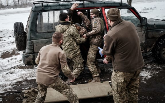 Paramedics receive an injured Ukrainian serviceman who stepped on an anti-personnel land mine near the frontline in the Donetsk region in January 2023.