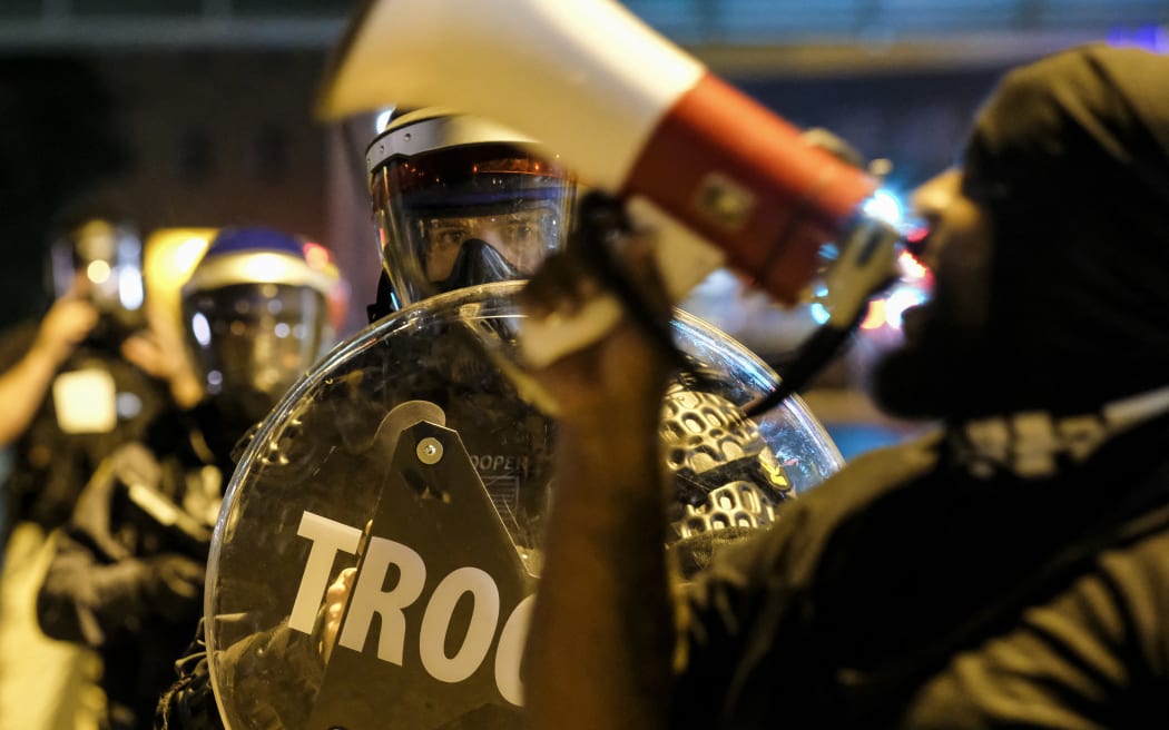 Troopers in riot gear watch as demonstrators gather outside Akron City Hall to protest the killing of Jayland Walker, shot by police, in Akron, Ohio, July 3, 2022.