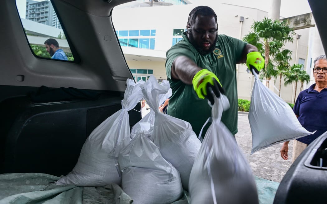 Volunteers from the city of Miami fill sandbags to help residents prepare for the arrival of Hurricane Milton in Miami, Florida on October 7, 2024. - Florida's governor has declared a state of emergency on Saturday as forecasters warned that Hurricane Milton is expected to make landfall later this week. (Photo by Giorgio VIERA / AFP)