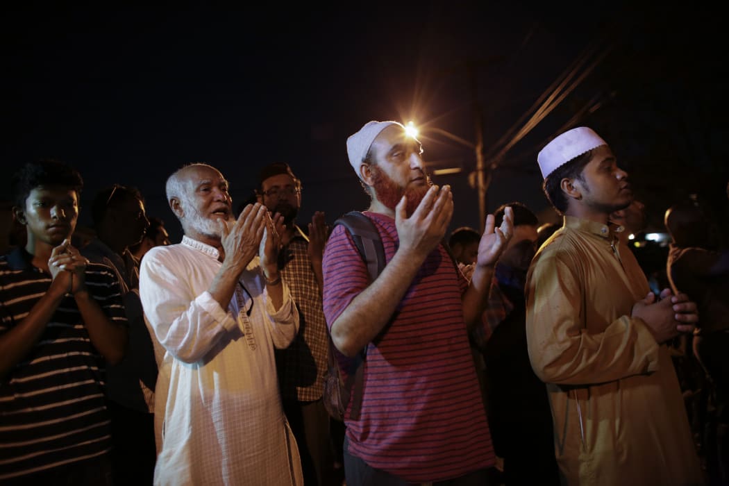 Community members pray outside the Al-Furqan Jame Mosque in Ozone Park after the fatal shootings.