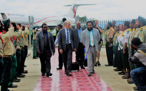 American evangelist Doug Batchelor (centre) is welcomed to Papua New Guinea's Mt Hagen by MP Don Polye (light suit, white tie), surrounded by saluting Seventh Day Adventist youths