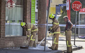 Firemen wash away bloodstains after a security guard was shot dead with another man fighting for his life after a drive-by shooting outside a popular Melbourne nightclub.