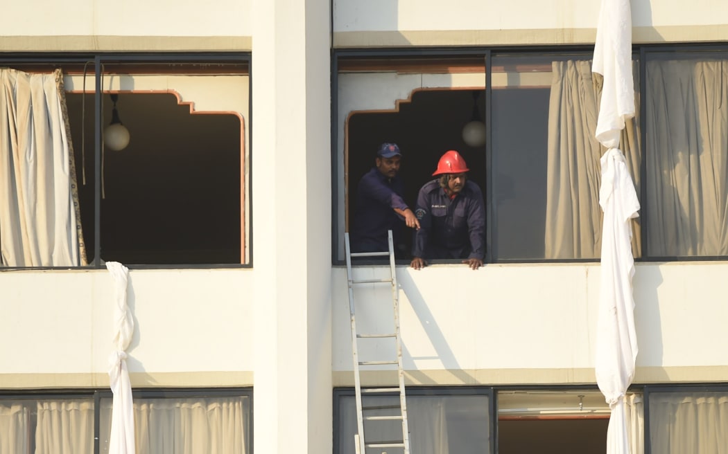 Firefighters look from a room of the Regent Plaza Hotel in Karachi after the fire was extinguished.