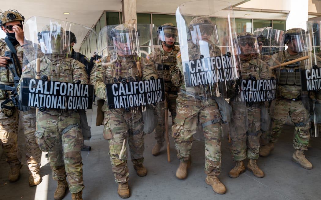 Protesters confront National Guard soldiers and police outside of a federal building as protests continue in Los Angeles.
