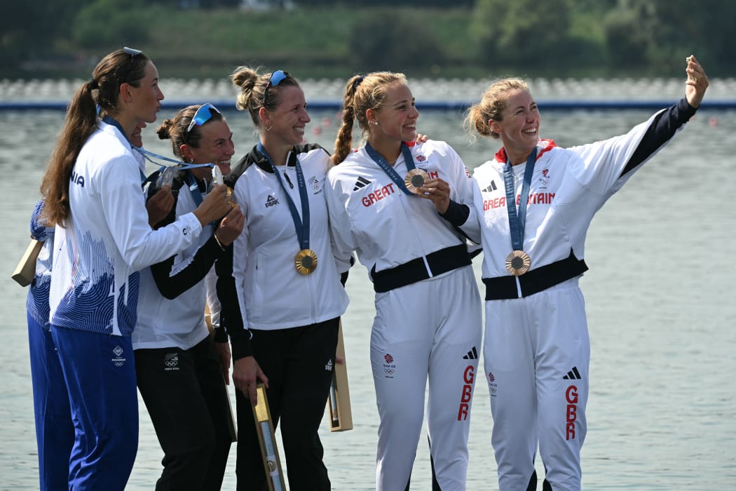 Silver medallists Romania's Ancuta Bodnar and Simona Radis, New Zealand's gold medallists Brooke Francis and Lucy Spoors, and bronze medallists Britain's Mathilda Hodgkins Byrne and Rebecca Wilde pose for a selfie photo on the podium during the medal ceremony after the women's double sculls final rowing competition at Vaires-sur-Marne Nautical Centre in Vaires-sur-Marne during the Paris 2024 Olympic Games on August 1, 2024. (Photo by Bertrand GUAY / AFP)