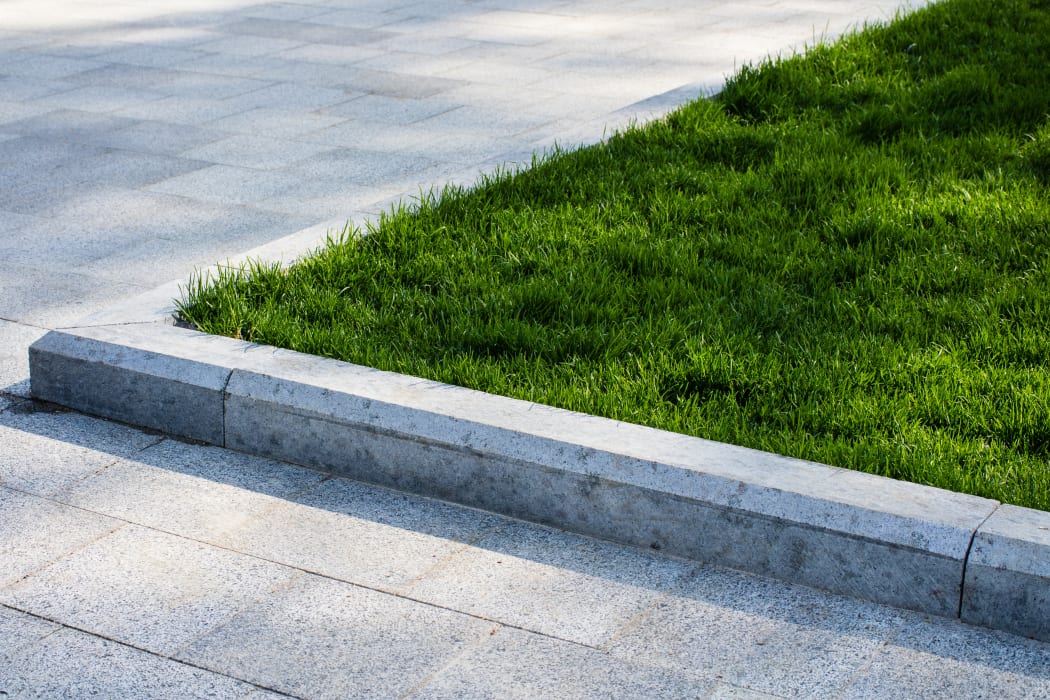 Green lawn on driveway, landscaping, berm.