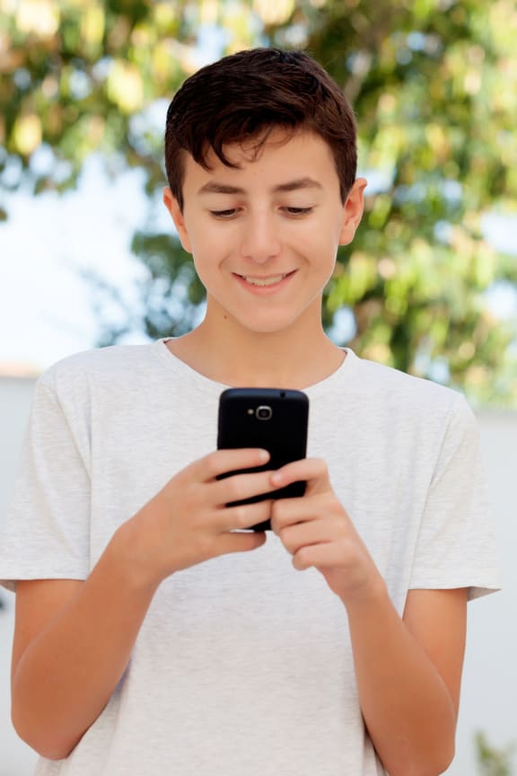 Funny teenage boy looking at the mobile