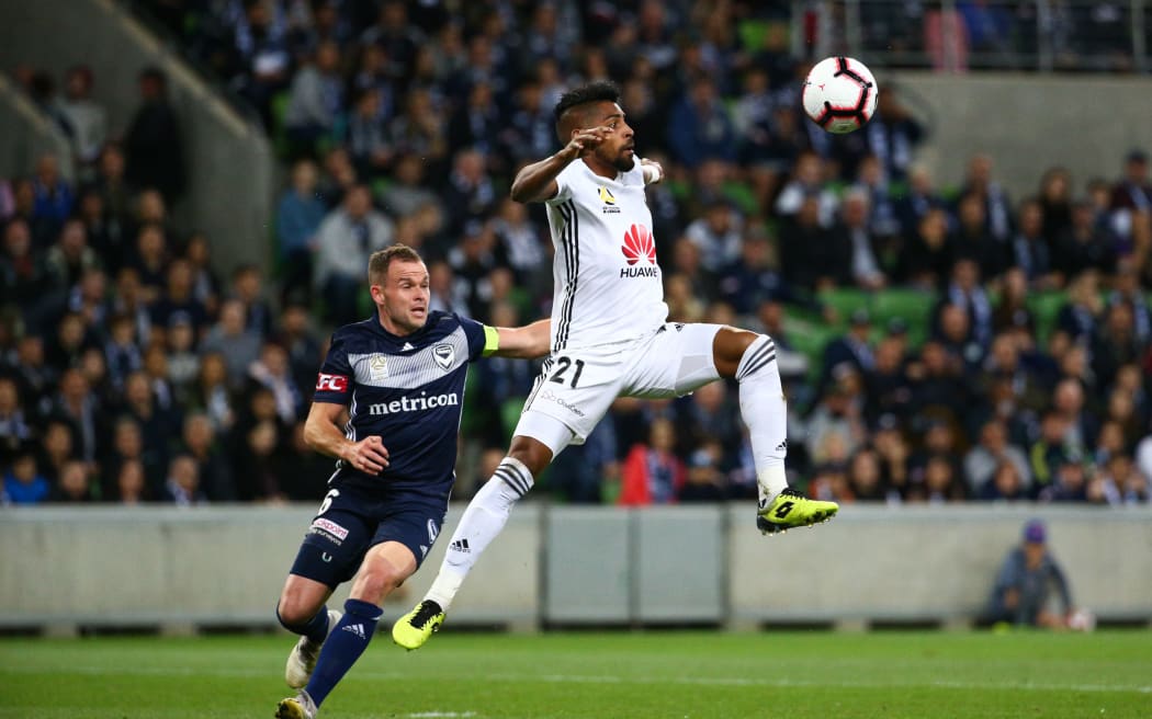 Roy Krishna of Wellington Phoenix controls the ball in front of Leigh Broxham of Melbourne Victory.