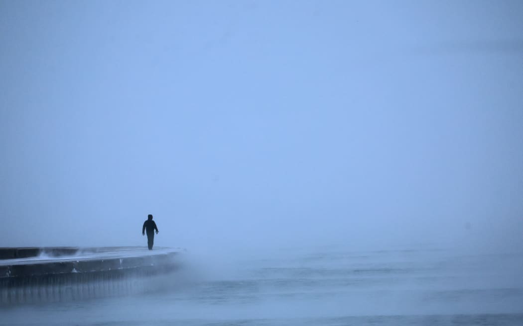 A man walks along Lake Michigan at sunrise amid sub-zero temperatures on December 22, 2022 in Chicago, Illinois.