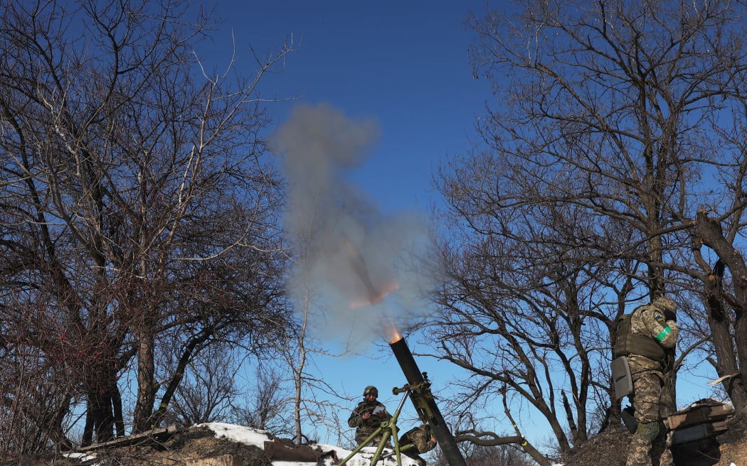 Ukrainian servicemen fire a mortar toward the Russian position on a frontline not far from Bakhmut in Donetsk region.