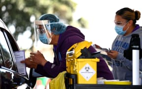 AUCKLAND, NEW ZEALAND - SEPTEMBER 25: A nurse hands out information after vaccinating a member of the public in their car during the Cook Islands drive through vaccination community event on September 25, 2021 in Auckland,