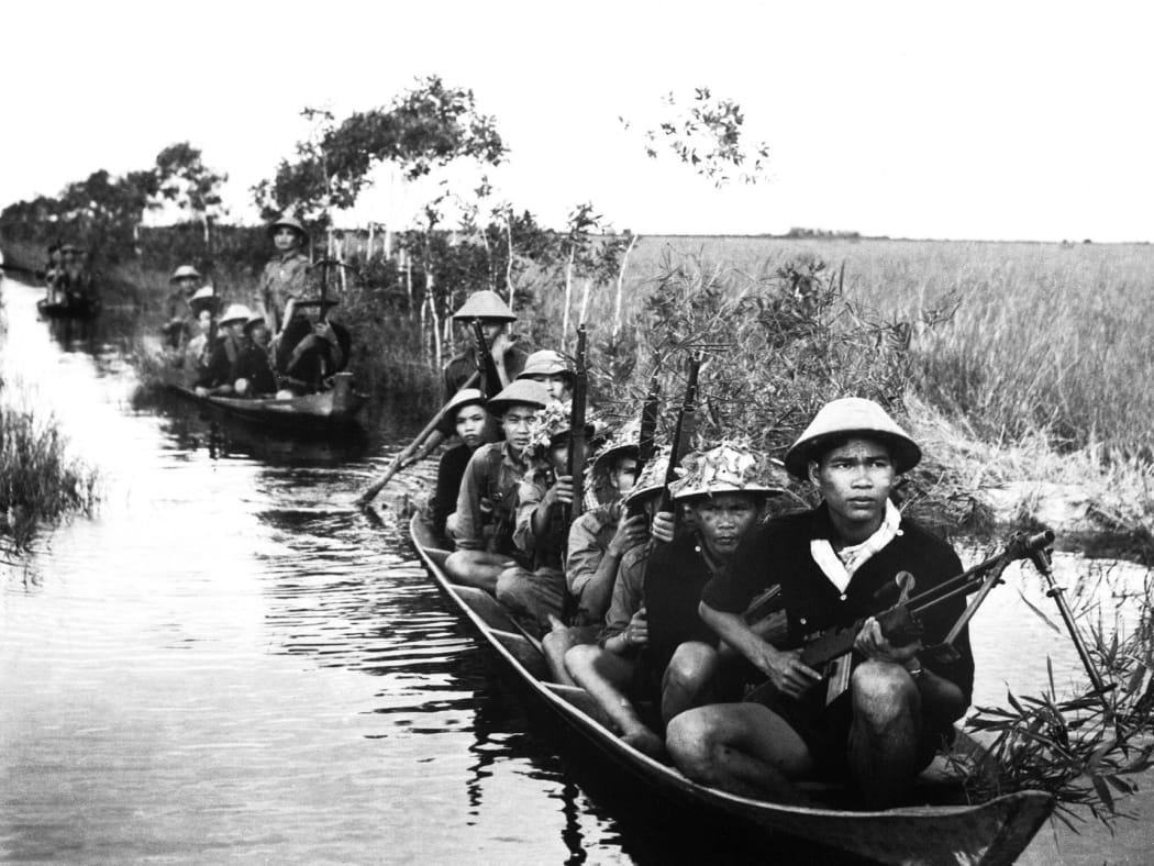 Viet Cong fighters crossing a river during the Vietnam War.