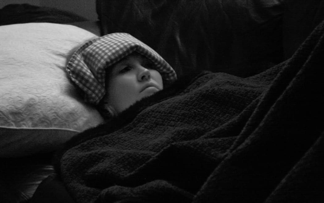 Migraine sufferer in a darkened room