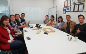 Chinese employees gather in Auckland to live stream China's national day parade.