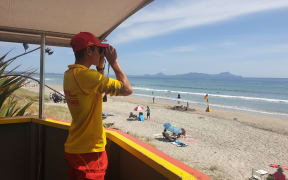 SLSNZ volunteer Surf Lifeguard with binoculars