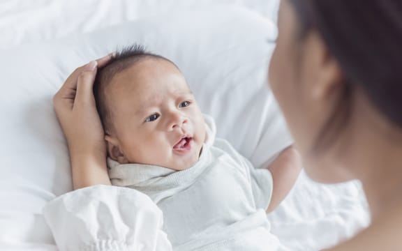 Mother hand holding and playing with newborn baby,