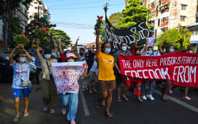 Protesters hold banners as they take part in a demonstration against the military coup in Yangon December 5, 2021.