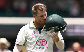 David Warner of Australia kisses the coat of arms on his helmet after being dismissed in his final test.