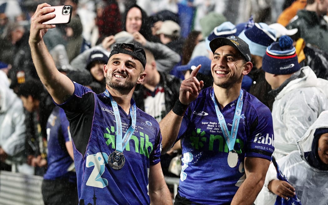 Blues players Harry Plummer and Bryce Heem (R) meet supporters after victory in the Super Rugby Pacific Final. 2024.
