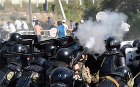 Kyrgyz special forces fire weapons as they block a street during clashes between supporters of Kyrgyzstan's former president and law enforcement, in the village of Koy-Tash.