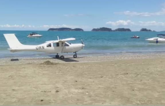 The plane begins to taxi down the beach.