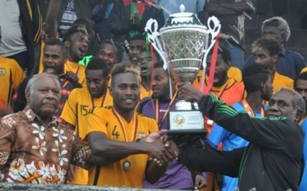 Vanuatu U23 football captain Brian Kaltack lifts the Friendship Cup trophy.
