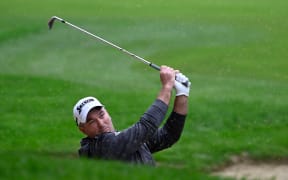 New Zealand golfer Ryan Fox hits out of a bunker.