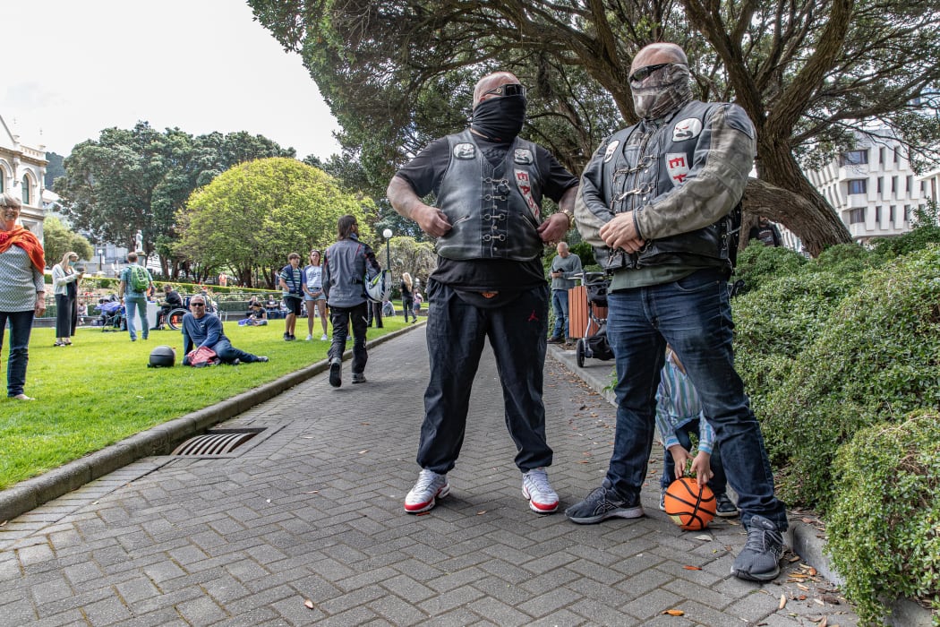 The staunch look of two members of the Headhunters East is undermined a little by the arrival of a small boy retrieving his ball from between the legs of one.
