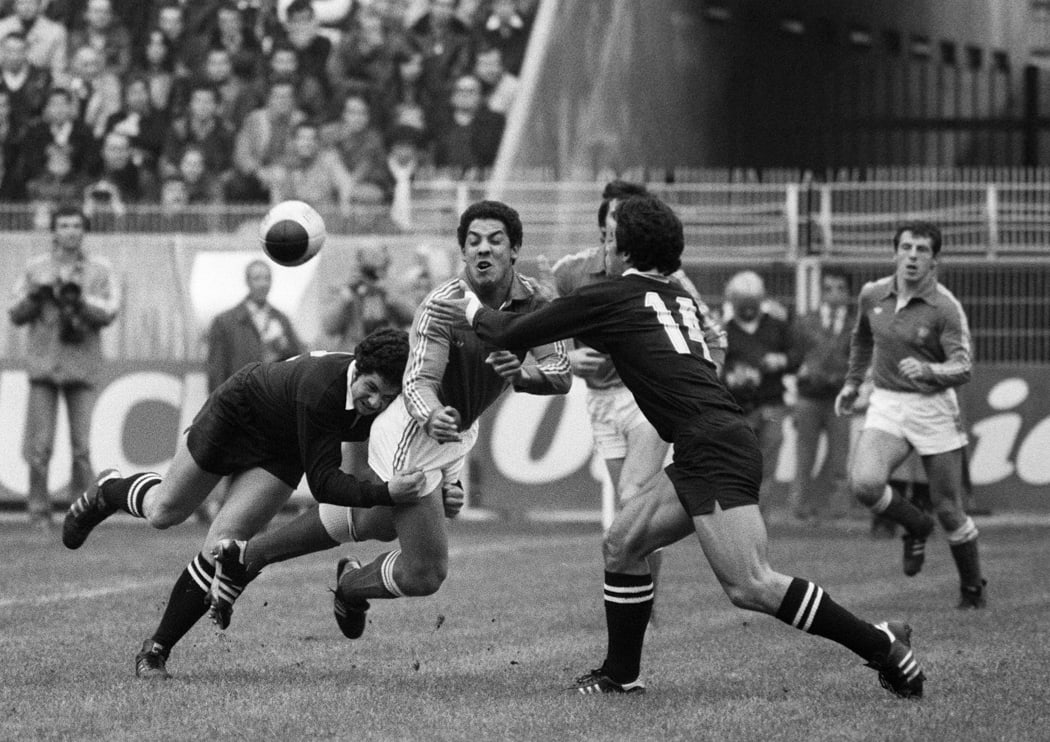 France's Serge Blanco (2nd left) is tackled while passing the ball by All Blacks Koteka (left) and Bernie Fraser (right).