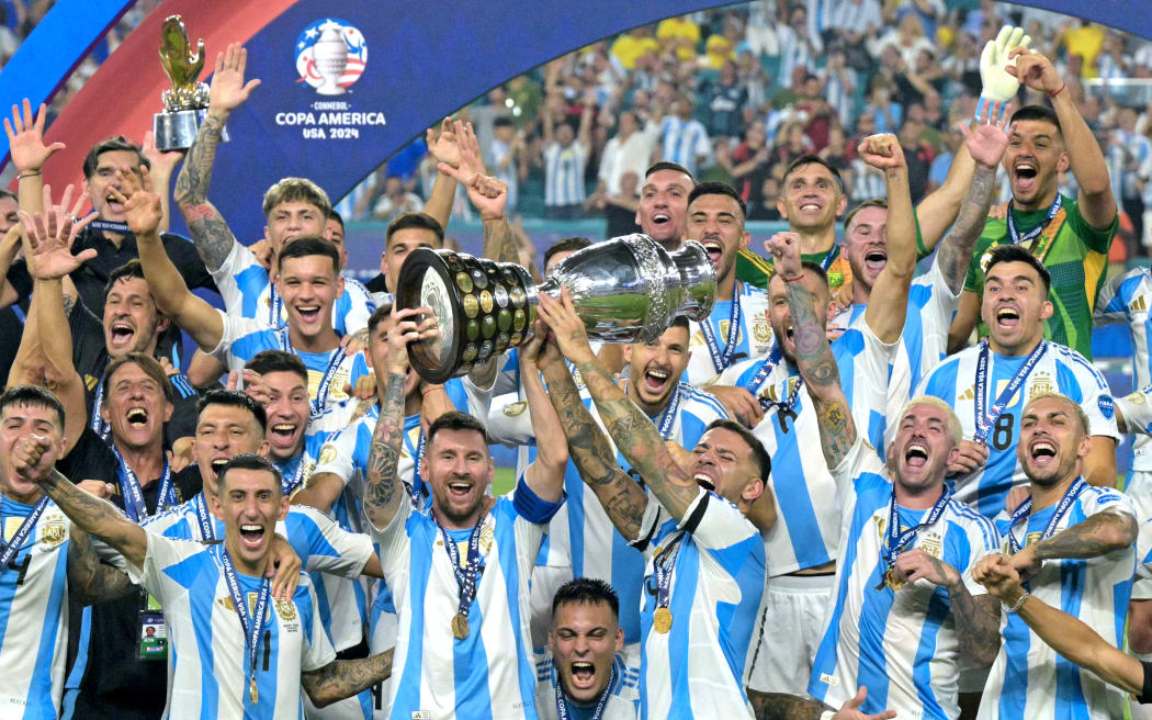 Argentina great Lionel Messi lifts the trophy as the team celebrate winning the 2024 Copa America tournament final against Colombia.