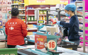 People shop at a supermarket in Wuhan, central China's Hubei Province, March 24, 2020.